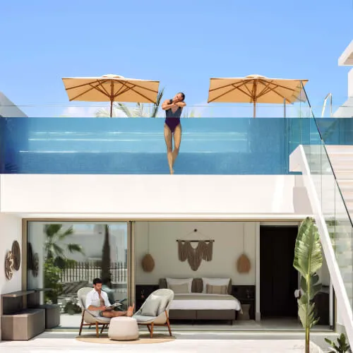 Ein Paar genießt das luxuriöse Pooldeck im 7Pines Ibiza Resort
