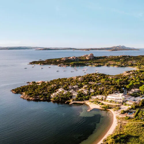 Luftaufnahme der 7Pines Resort Küstenlinie mit Luxussuiten, die auf Es Vedrà, Ibiza, blicken.