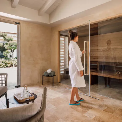 Woman in bathrobe standing indoors at 7Pines Hotels & Resorts