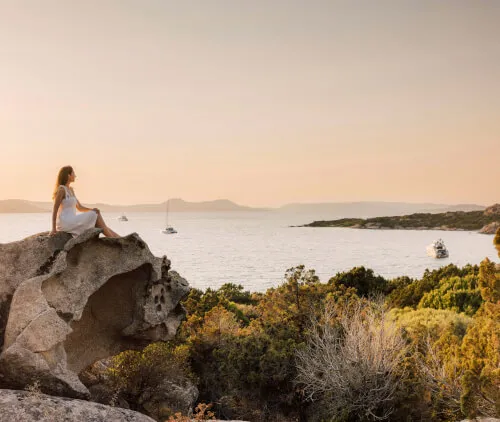 Frau genießt einen ruhigen Moment auf einem Felsen bei 7Pines Hotels & Resorts